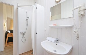 A bathroom with a shower, sink, and mirror. - Frische Brise 19 - Dorf 3 (Lübeck)