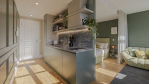Una cucina moderna con elettrodomestici integrati, una parete di fondo in marmo e scaffalature a scomparsa.