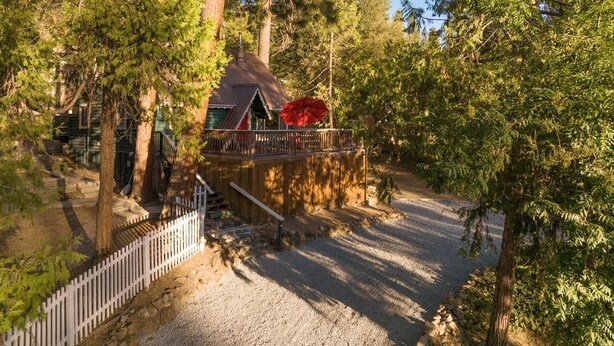 A rustic cabin with a wooden deck, surrounded by dense trees. - Cabin in the forest, close to Bass Lake & Yosemite, mountain views & deck (Oakhurst)