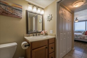 A bathroom with a sink, mirror, and a towel rack.