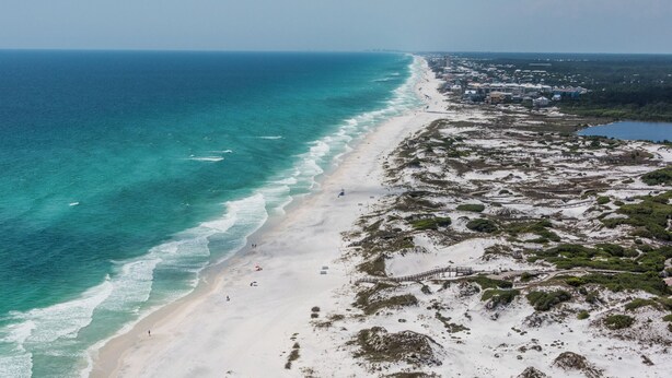 An aerial view of a beach with a clear view of the ocean, sandy shore, and a mix of vegetation and buildings along the coastline. - Private Pool & Feet to the Beach, Near to Chiringo & Red Bar + Free Tickets! (Santa Rosa Beach)