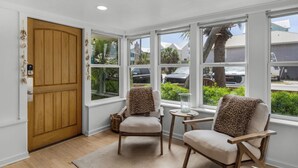 A sunroom with two chairs, a small table, and a view of the outside. - Private Pool & Feet to the Beach, Near to Chiringo & Red Bar + Free Tickets! (Santa Rosa Beach)