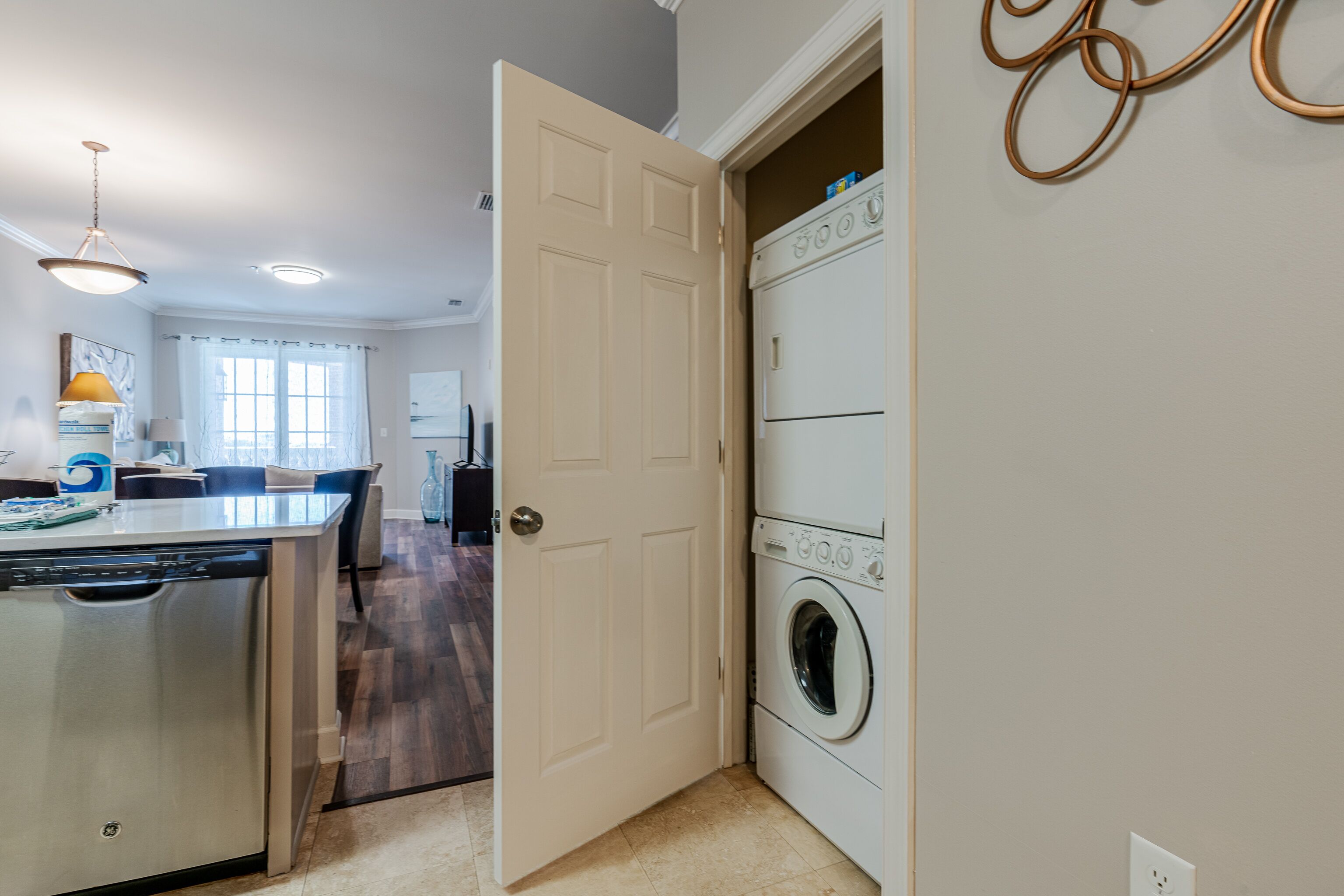 A compact kitchen with a dishwasher, a washing machine, and a dining area with a table and chairs.