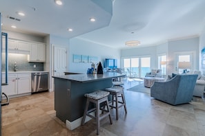 A spacious kitchen with a central island, bar stools, and a modern bar area.