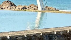 A concrete structure with a metal staircase leading to a platform over water, surrounded by rocks and a clear sky. - Vacation home, 400m from the sea in a quiet, well-located area (Saint-Quay-Portrieux)