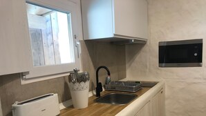 A compact kitchen with a toaster, a sink, and a microwave. - Kaolin Rocabella Apartment with Private Sandy Pool (El Chorro)