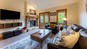 A living room with a fireplace, a television, a sofa, and a coffee table. - Close to Gondola and Short Walk to Keystone Base Area Shops and Dining! (Keystone)