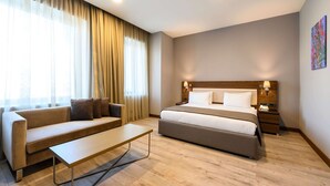 A modern hotel room with a bed, sofa, and a small table. - La Quinta by Wyndham Istanbul Gunesli (Istanbul)