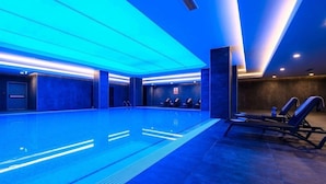 A swimming pool with blue lighting, lounge chairs, and a tiled floor. - La Quinta by Wyndham Istanbul Gunesli (Istanbul)