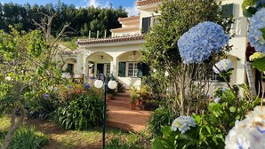 Una villa con jardín, un patio y una escalera que lleva a la entrada.
