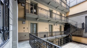 A multi-story residential building with balconies, a staircase, and a door. - Italianway - The B Village Superior (Milan)