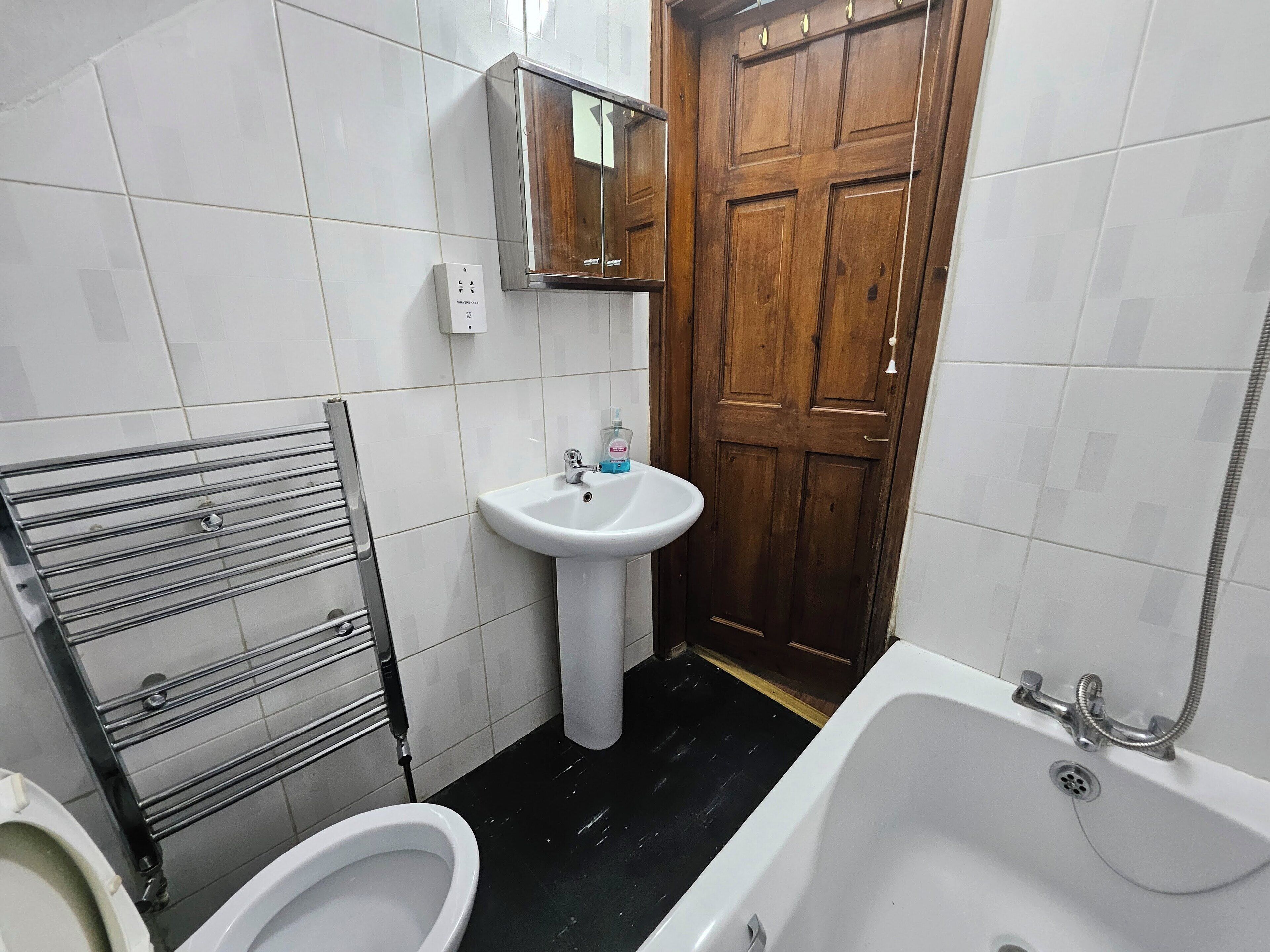 A bathroom with a toilet, sink, and bathtub.