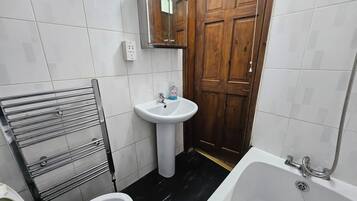 A bathroom with a toilet, sink, and bathtub.
