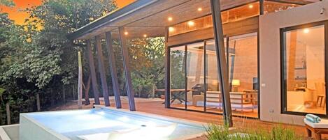 A modern house with a swimming pool, large windows, and a covered patio.