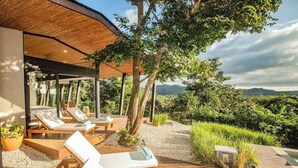 A covered outdoor seating area with lounge chairs and a view of the surrounding landscape. - Casa La Reina, Private Jungle Villa (Tamarindo)