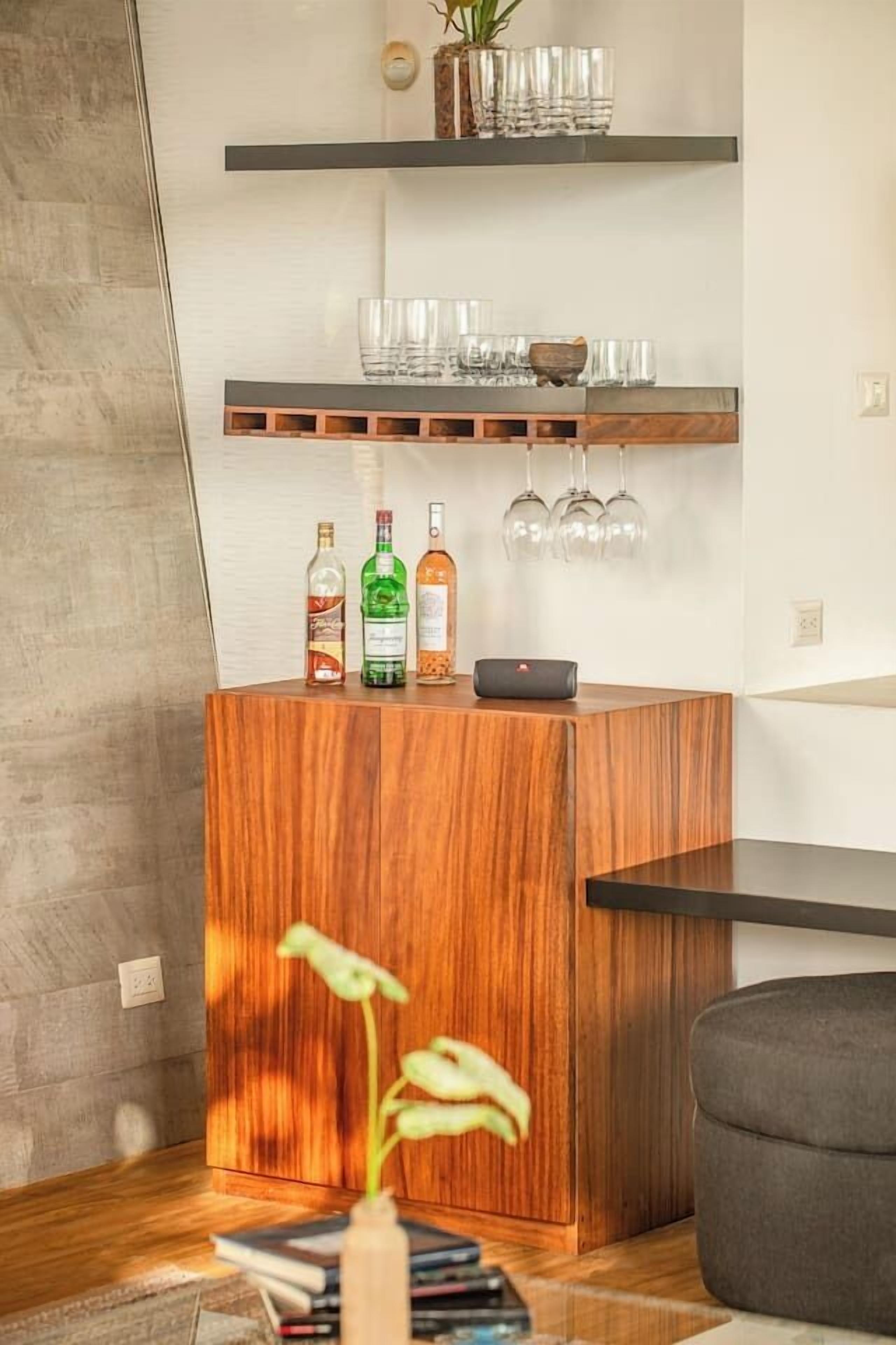 Un comptoir d’accueil en bois agrémenté d’une plante, d’un vase et de quelques bouteilles.