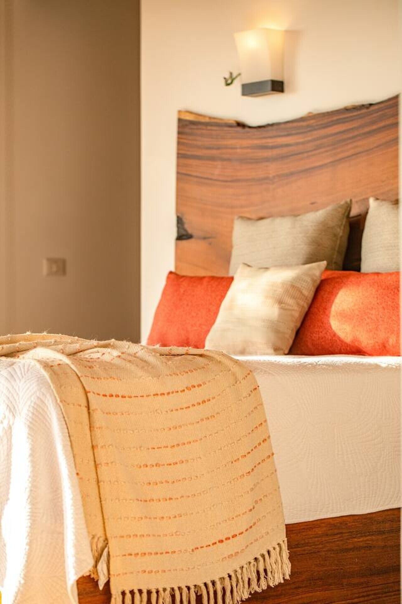 A bed with a headboard, pillows, and a blanket.