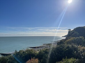 A coastal landscape with a clear sky, a calm sea, and a wooden pier extending into the water. - Spacious 2-bed Apartment With Free Parking (Eastbourne)