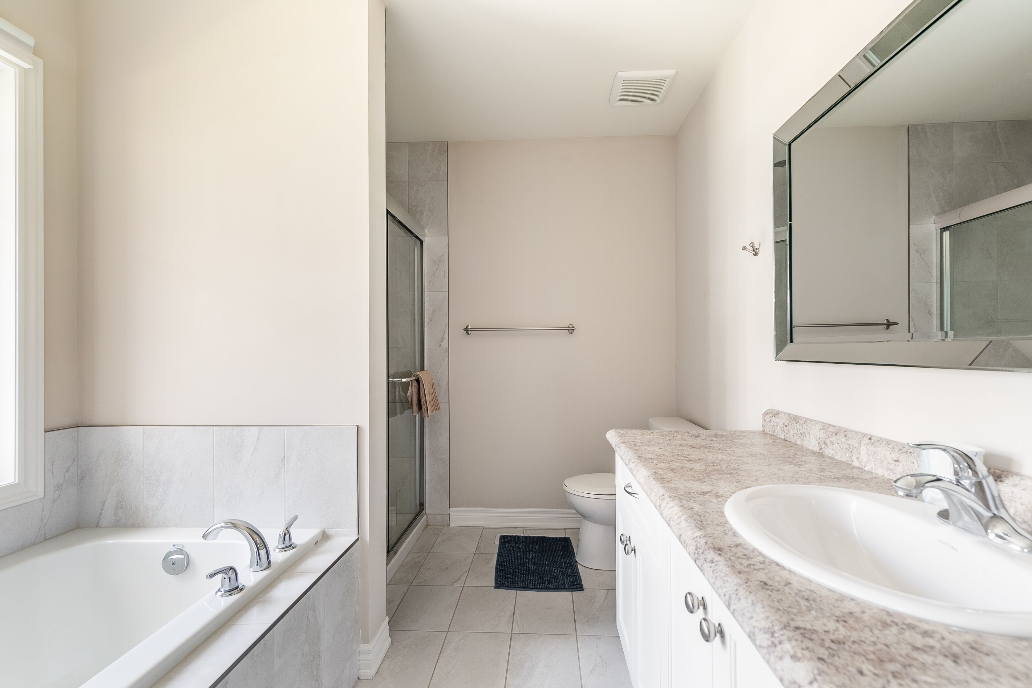 A modern bathroom with a bathtub, a sink, and a shower.