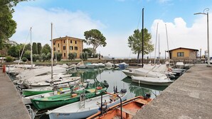 Un puerto deportivo con barcos amarrados, un edificio al fondo y cielo despejado.