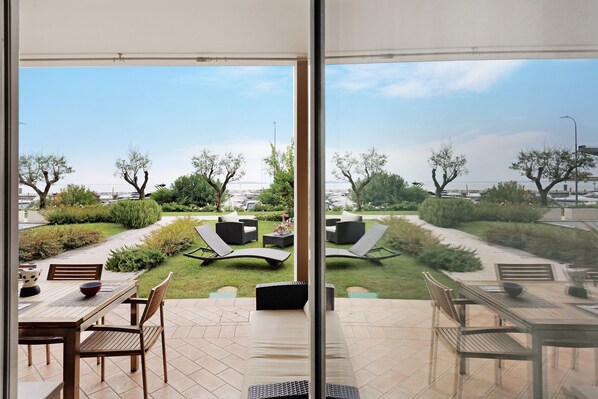 A patio area with outdoor seating and a view of a landscaped garden.