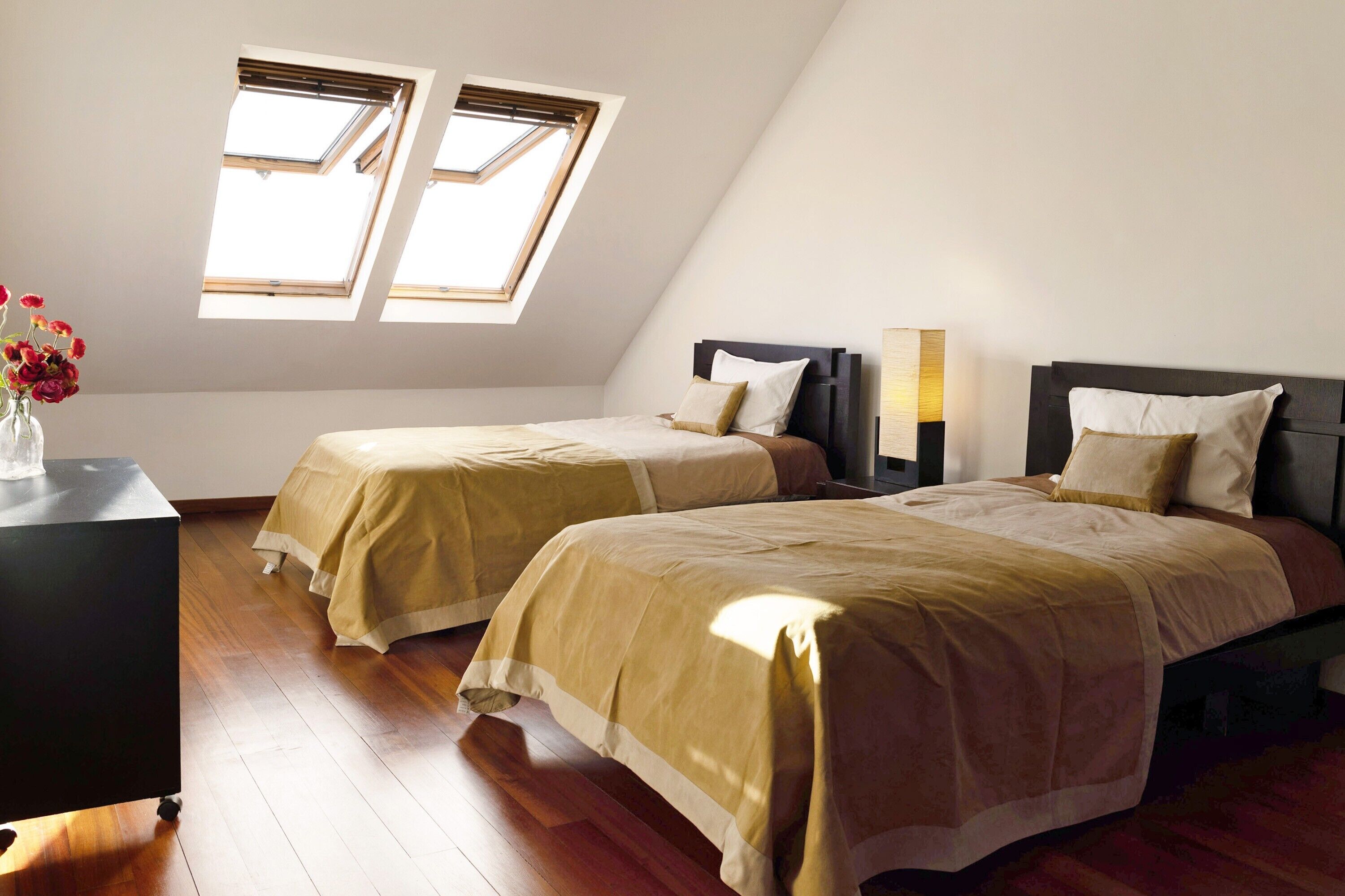 Une chambre avec deux lits, un bureau et une fenêtre donnant sur un beau paysage.
