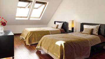 Une chambre avec deux lits, un bureau et une fenêtre donnant sur un beau paysage.