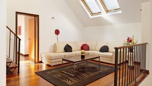 Een moderne woonkamer met een bank, salontafel en een trap.