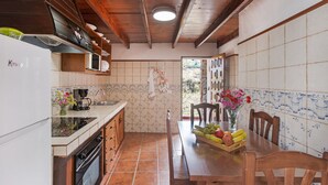 A kitchen with wooden beams, a white refrigerator, tiled backsplash, and a dining table with chairs. - Holiday Home "Casa Los Diablitos" – Family-Friendly with Mountain Views, Terrace & Wi-Fi (Santa Cruz de Tenerife)