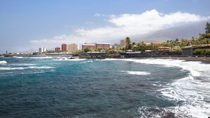 Een kuststreeatsilhouette met een strand, oceaan en gebouwen op de achtergrond.