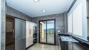 Una cocina moderna con horno empotrado, refrigerador y lavamanos.