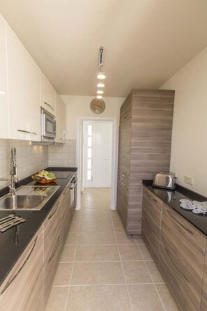 Una cocina moderna con microondas, fregadero y tostadora.