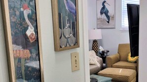 A living room with a sofa, ottoman, and a ceiling fan. - COZY- Quiet Cottage Pets Kitchen (Tallahassee)