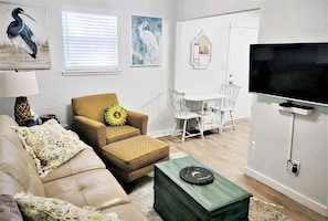 Relax in this stylish living room with a comfortable sofa, dining table, and flat-screen TV.