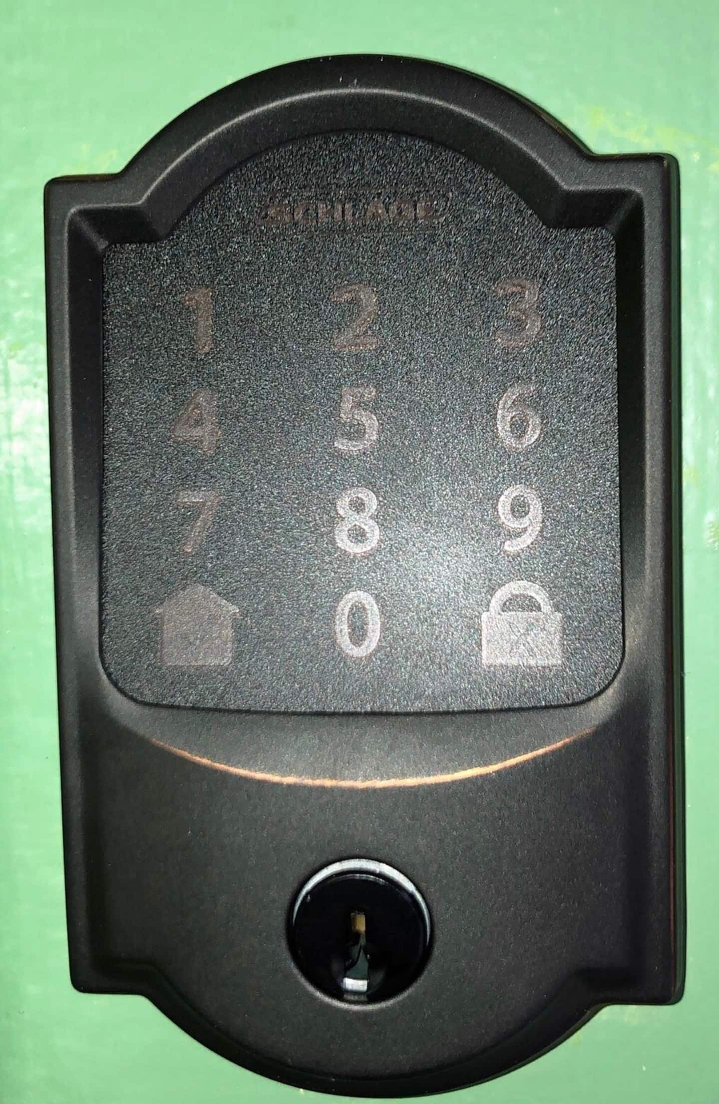 Ett svart numeriskt tangentbord med siffrorna 1–9, 0 samt symboler för hus, lås och radering.