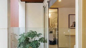 A modern interior with a wooden ceiling, a glass door leading to a bathroom, and a potted plant. - w* | Splendid 1BR with Perfect Balcony in Polanco (Ciudad de México)