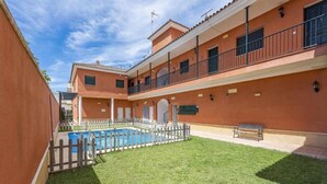 A building with a swimming pool, a fenced area, and a bench. - Holiday Apartment 'Torero II' with Pool, Private Balcony and Wi-Fi (Sevilla)