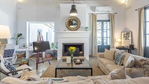 Ein Wohnzimmer mit Kamin, einer Couch, einem Couchtisch und einem Fernseher.