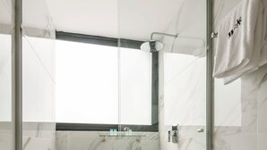 A modern bathroom with a glass-enclosed shower, a white toilet, and marble walls. - w* | Stunning 1BR with Perfect Deco in Polanco (Ciudad de México)