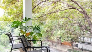 A covered balcony with a view of a street and trees. - w* | Enchanting 1BR w/ Terrace in Prime Polanco (Ciudad de México)