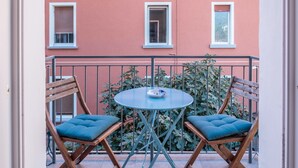 A balcony with two wooden chairs and a small round table. - Apartment "Isabel" with Mountain View, French Balcony & Wi-Fi (Bolzano)