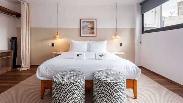 A modern hotel room with a large bed, two bedside tables, a framed picture on the wall, and a window with a view. - w* | Fascinating 1BR with Perfect Deco in Polanco (Ciudad de México)