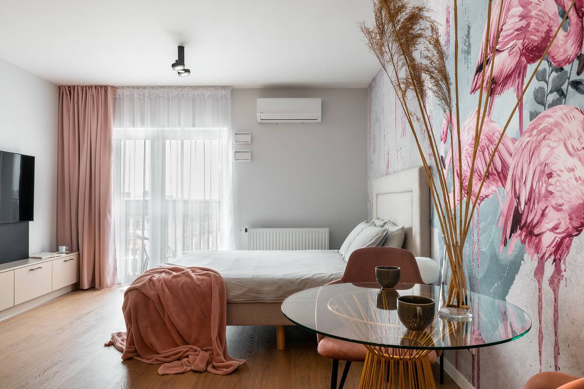 Een moderne slaapkamer met een bed, nachtkastje en een glazen tafel met stoelen.