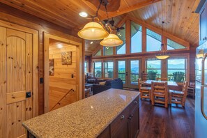 A spacious kitchen with granite countertops, wooden cabinets, and a dining area with a table and chairs.