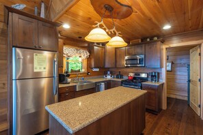 A modern kitchen with wooden cabinets, stainless steel appliances, granite countertops, and a large island.