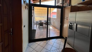 A kitchen with a sliding glass door leading to an outdoor patio area. - Apartment With Terrace Close to Catania, Sicily (Adrano)