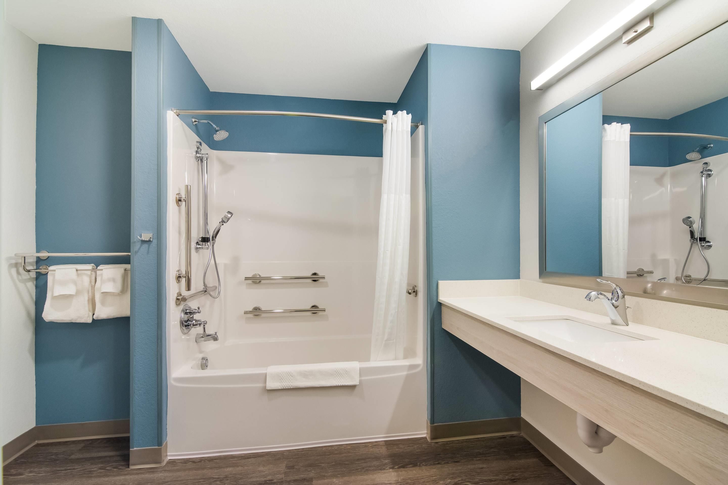 Un baño moderno con bañera, ducha y lavamanos dobles.