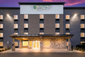 A hotel with a modern facade, a sign reading "Woodspring Suites," and the address "320 N Gallaher View Rd." - WoodSpring Suites Knoxville West (Knoxville)