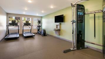 Une salle de remise en forme équipée de tapis de course, d’un vélo d’appartement et d’une machine de musculation.