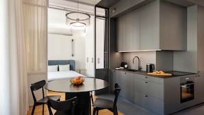 Una cucina moderna con mobili grigi, un tavolo rotondo con sedie e un'isola per la colazione.